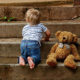 Child climbing steps and a teddy